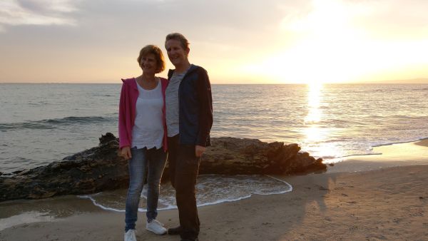 Mann und Frau am Meer bei Sonnenuntergang